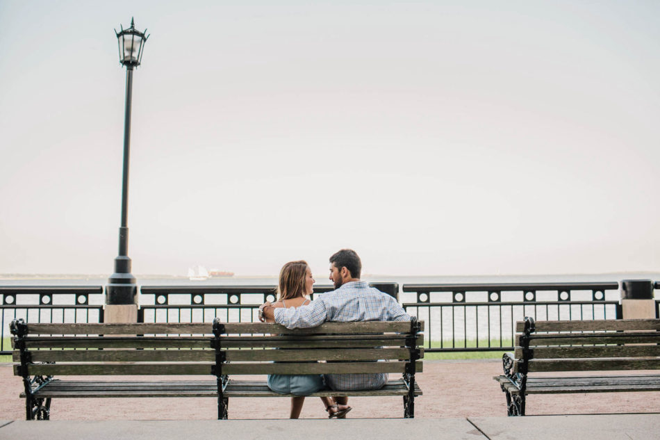 Engaged couple sits on a bench, watching the ocean, Waterfront Park, Charleston, South Carolina Kate Timbers Photography. http://katetimbers.com #katetimbersphotography // Charleston Photography // Inspiration