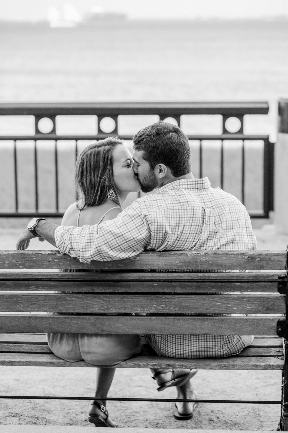 Engaged couple sits on a bench, watching the ocean, Waterfront Park, Charleston, South Carolina Kate Timbers Photography. http://katetimbers.com #katetimbersphotography // Charleston Photography // Inspiration