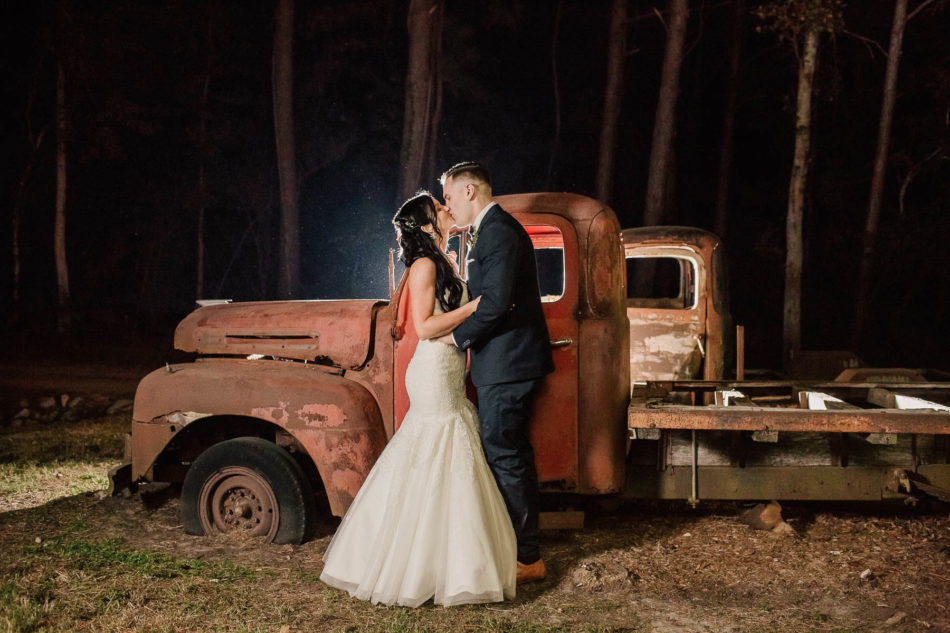 Bride and groom pose by red rustic truck at night, Boals Farm, Charleston, South Carolina Kate Timbers Photography. http://katetimbers.com #katetimbersphotography // Charleston Photography // Inspiration