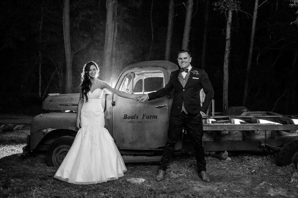 Bride and groom pose by red rustic truck at night, Boals Farm, Charleston, South Carolina Kate Timbers Photography. http://katetimbers.com #katetimbersphotography // Charleston Photography // Inspiration
