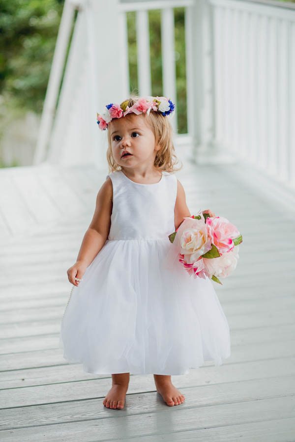 Flowergirl stands on porch, Creek Club at I'ON, Charleston, South Carolina. Kate Timbers Photography. http://katetimbers.com