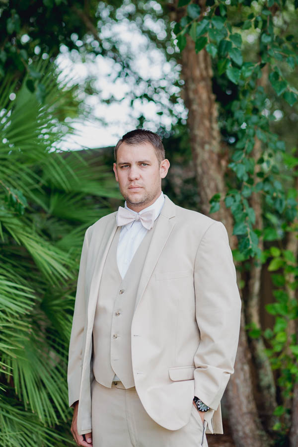 Groom stands by palm trees, Creek Club at I'on, Charleston, South Carolina. Kate Timbers Photography. http://katetimbers.com