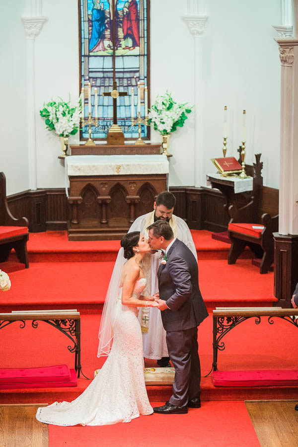 Bride and groom kiss, Church of the Holy Cross, Sullivans Island, Charleston, SC, Hurricane Joaquin. Kate Timbers Photography. katetimbers.com