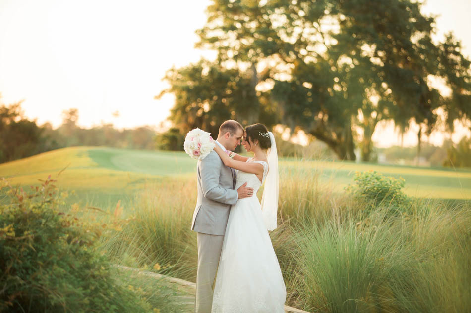 Bride and groom stand in a field at sunset, Daniel Island Club. Kate Timbers Photography. http://katetimbers.com