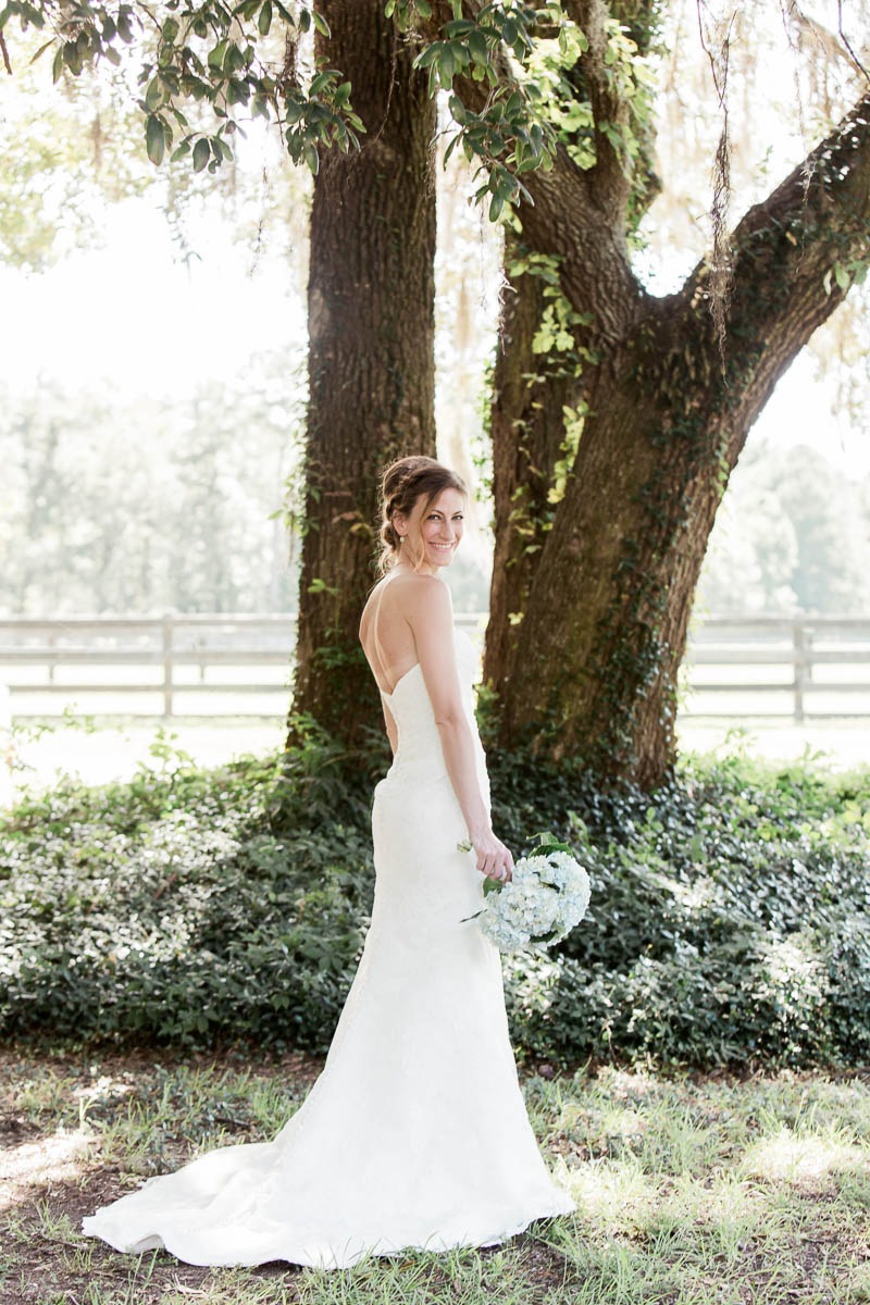 Bride poses under the oak tree, Pepper Plantation, Awendaw, South Carolina. Kate Timbers Photography. http://katetimbers.com