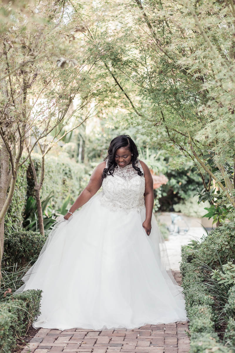 Bride stands in garden, Downtown Private Estate, Charleston. Kate Timbers Photography. http://katetimbers.com