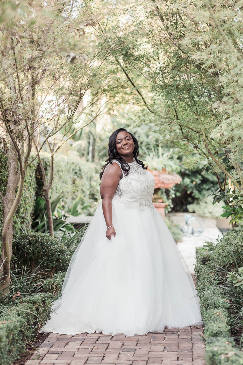 Bride stands in garden, Downtown Private Estate, Charleston. Kate Timbers Photography. http://katetimbers.com