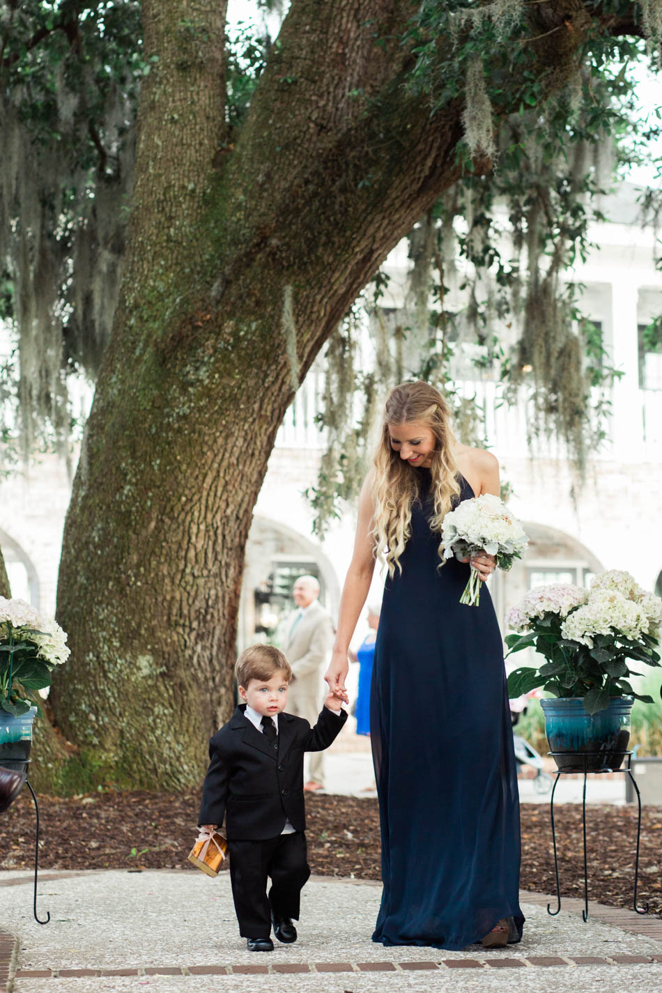 Bridesmaid and ring bearer walk down the aisle, Dunes West Golf and River Club, Mt Pleasant, South Carolina. Kate Timbers Photography. http://katetimbers.com