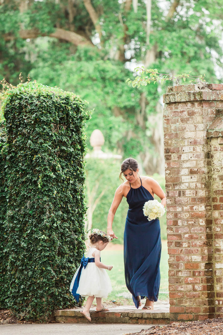 Flower girl steps into the garden, Dunes West Club, Mt Pleasant, South Carolina. Kate Timbers Photography. http://katetimbers.com
