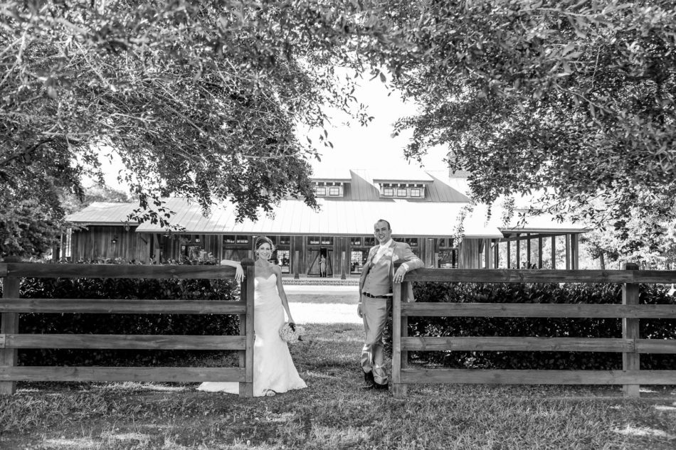 Bride and groom pose in front of fence, Pepper Plantation, Awendaw, South Carolina. Kate Timbers Photography. http://katetimbers.com