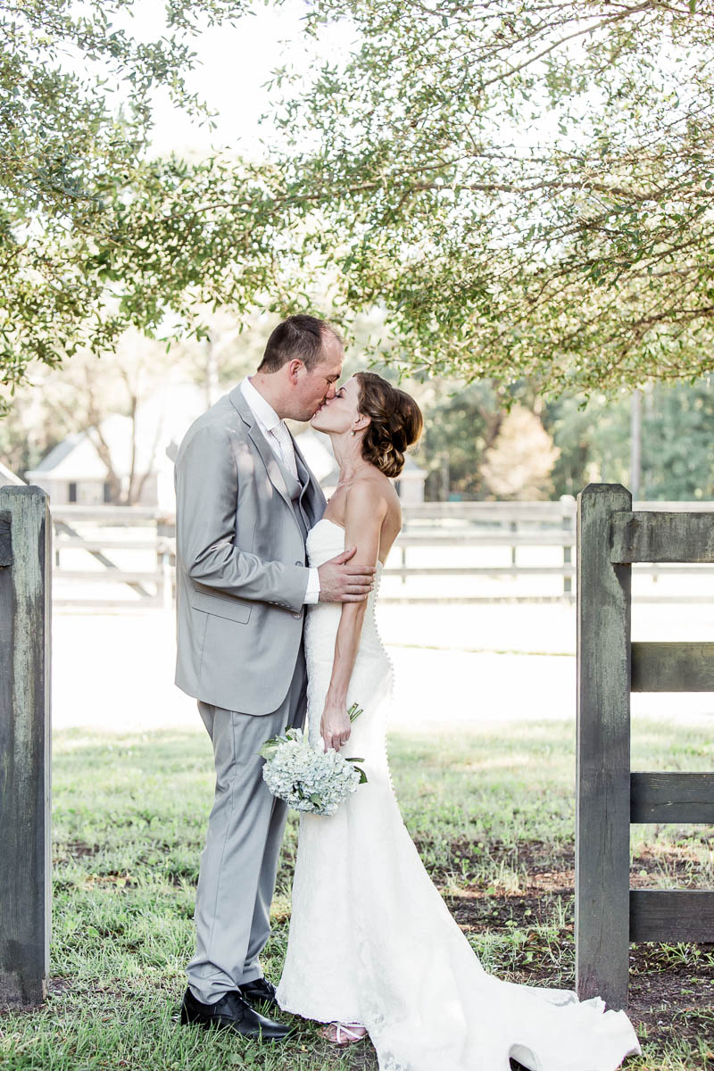 Bride and groom pose in front of fence, Pepper Plantation, Awendaw, South Carolina. Kate Timbers Photography. http://katetimbers.com