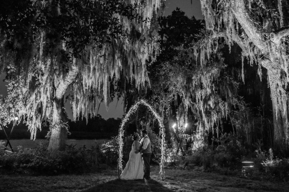 Bride and groom stand under lit up oak tree, Magnolia Plantation. Kate Timbers Photography. http://katetimbers.com