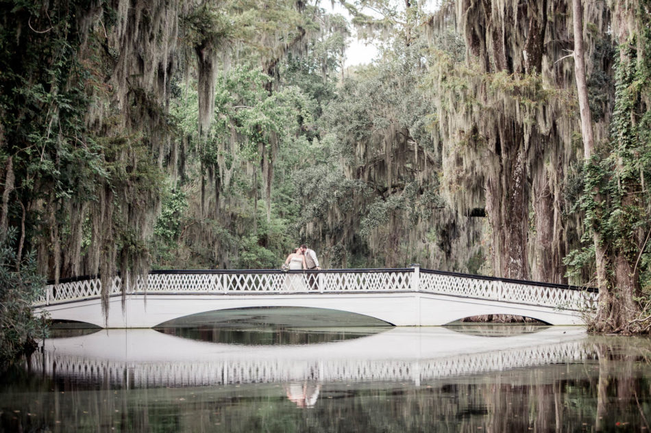 Bride and groom stand on white bridge, Magnolia Plantation. Kate Timbers Photography. http://katetimbers.com