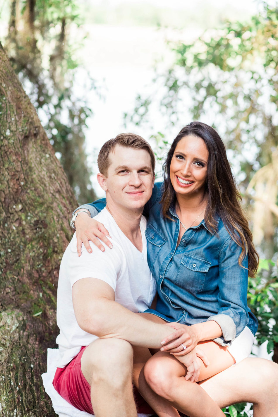 Engaged couple sit on the oak tree that is near the water's edge, Magnolia Plantation, Charleston, South Carolina. Kate Timbers Photography. http://katetimbers.com