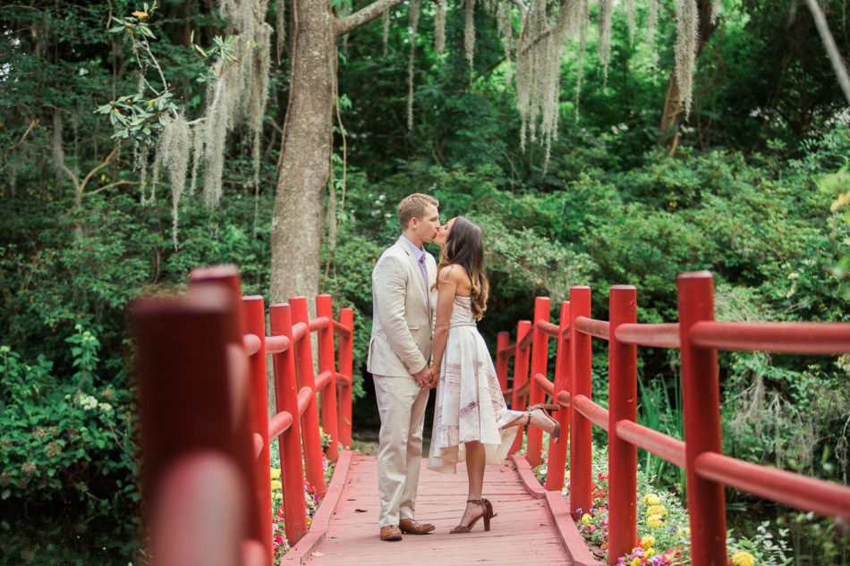 Engaged couple stand on a red bridge, Magnolia Plantation, Charleston, South Carolina. Kate Timbers Photography. http://katetimbers.com