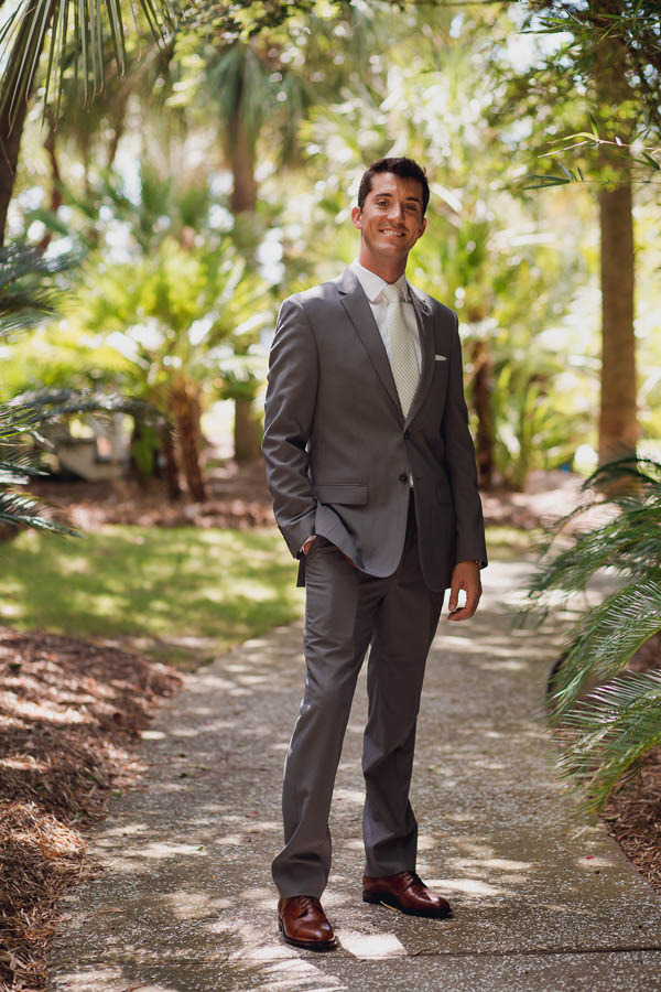 Groom stands under palm trees, Cottages on Charleston Harbor, Mt Pleasant, South Carolina. Kate Timbers Photography. http://katetimbers.com