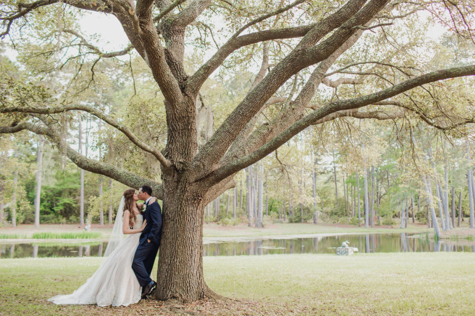 Bride and groom stand by tree, Brookgreen Gardens, Murrells Inlet, South Carolina. Kate Timbers Photography. http://katetimbers.com