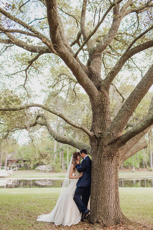 Bride and groom stand by tree, Brookgreen Gardens, Murrells Inlet, South Carolina. Kate Timbers Photography. http://katetimbers.com