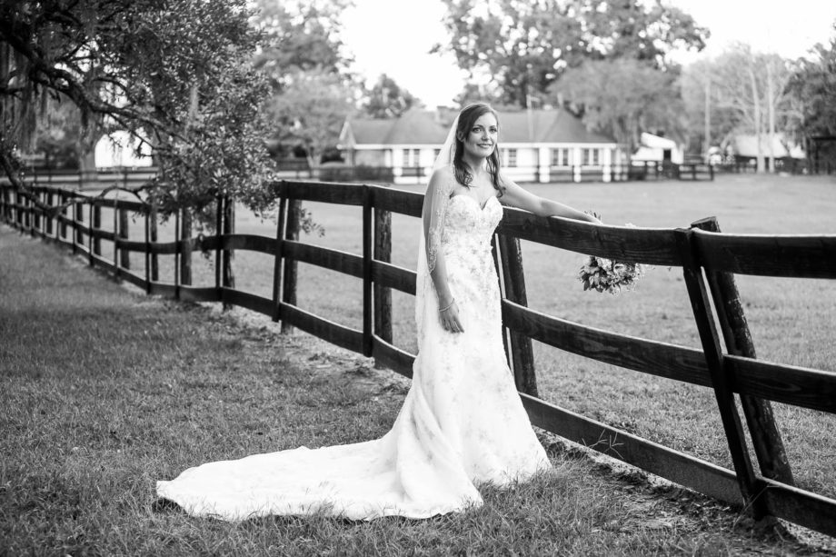 Bride leans on fence, Boone Hall Plantation, Charleston, South Carolina. Kate Timbers Photography. http://katetimbers.com