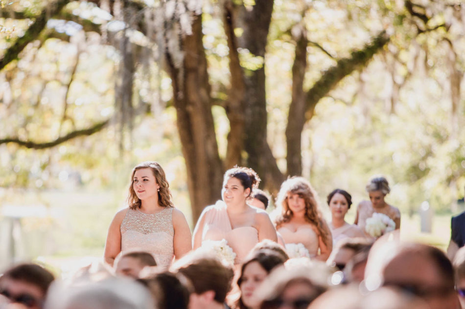 Bridesmaids walk up aisle, Brookgreen Gardens, Murrells Inlet, South Carolina. Kate Timbers Photography. http://katetimbers.com