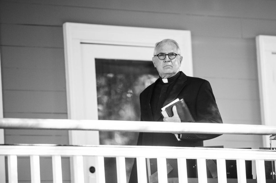 Priest clutches bible, Creek Club at I'on, Charleston, South Carolina. Kate Timbers Photography. http://katetimbers.com