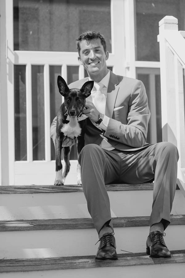 Groom sits with dog, Cottages on Charleston Harbor, Mt Pleasant, South Carolina. Kate Timbers Photography. http://katetimbers.com