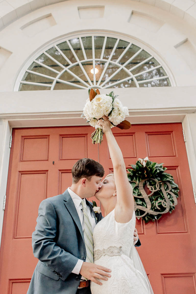 Bride and groom pose in front of red door at Coleman Hall, Mt Pleasant, South Carolina Kate Timbers Photography. http://katetimbers.com #katetimbersphotography // Charleston Photography // Inspiration