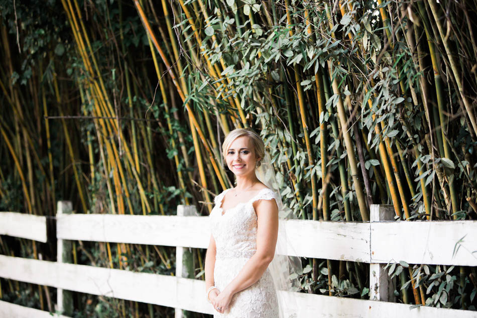 Bride stands near bamboo and white fence, Alhambra Hall, Mt Pleasant, South Carolina Kate Timbers Photography. http://katetimbers.com #katetimbersphotography // Charleston Photography // Inspiration