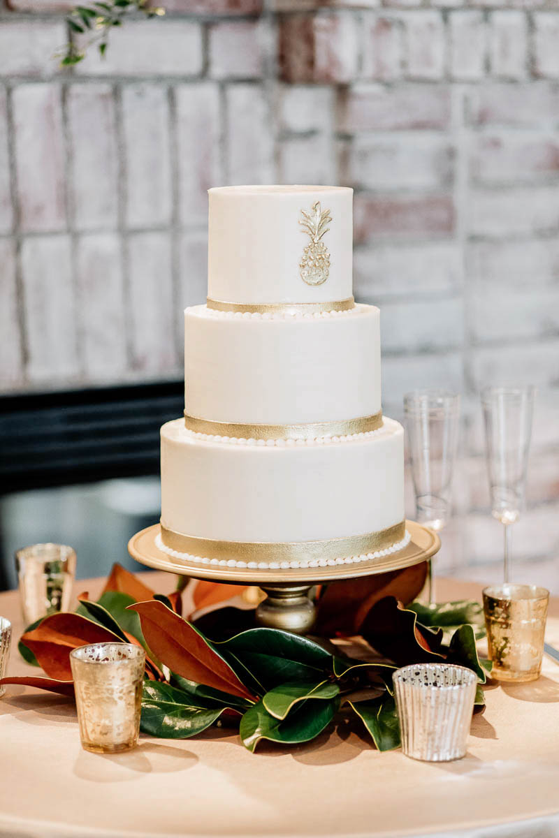 A gold and white cake is accented with a pineapple, Coleman Hall, Mt Pleasant, South Carolina Kate Timbers Photography. http://katetimbers.com #katetimbersphotography // Charleston Photography // Inspiration