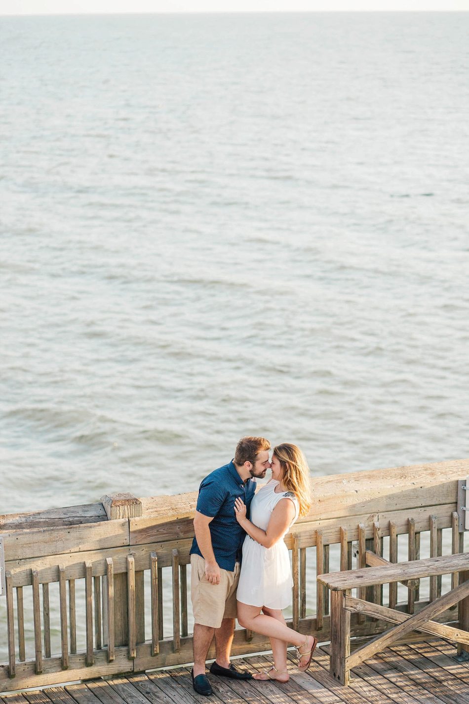 Engaged Couple kiss on pier, Folly beach in Charleston, South Carolina Kate Timbers Photography. http://katetimbers.com #katetimbersphotography // Charleston Photography // Inspiration