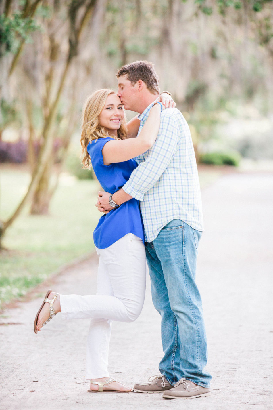 Engaged couple stand in pathway full of trees and spanish moss, Hampton Park, Charleston, South Carolina Kate Timbers Photography. http://katetimbers.com #katetimbersphotography // Charleston Photography // Inspiration