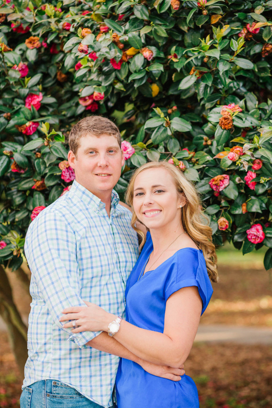 Engaged couple poses in front of tree with red flowers, Hampton Park, Charleston, South Carolina Kate Timbers Photography. http://katetimbers.com #katetimbersphotography // Charleston Photography // Inspiration