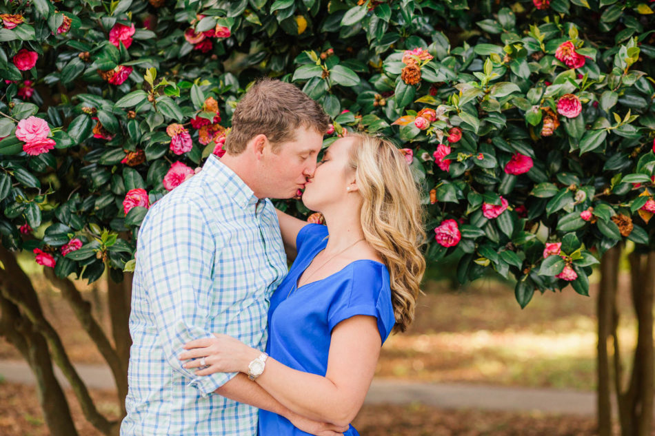 Engaged couple poses in front of tree with red flowers, Hampton Park, Charleston, South Carolina Kate Timbers Photography. http://katetimbers.com #katetimbersphotography // Charleston Photography // Inspiration