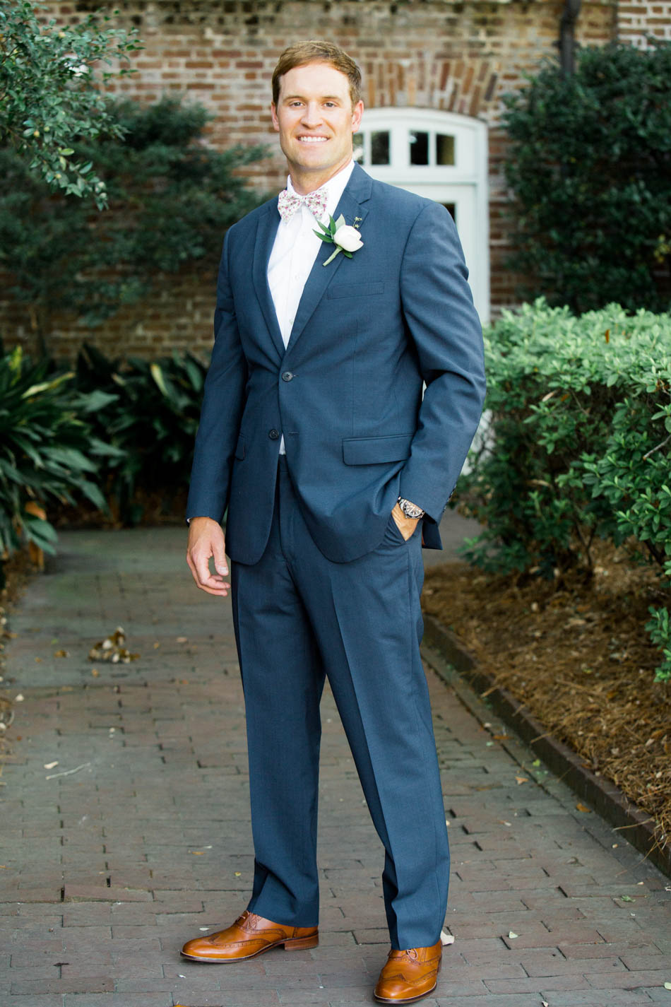 Groom stands in front of the Rice Mill Building, Charleston, South Carolina Kate Timbers Photography. http://katetimbers.com #katetimbersphotography // Charleston Photography // Inspiration