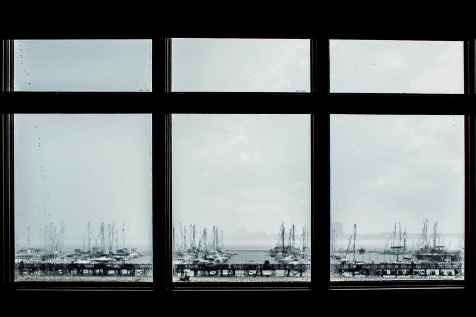 Rain pours on windows looking out to the boats of Charleston Harbor Marina. www.katetimbers.com