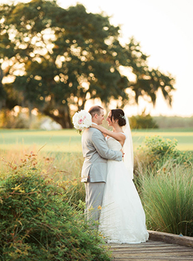 Bride and groom stand in a field at sunset, Daniel Island Club. Kate Timbers Photography. http://katetimbers.com