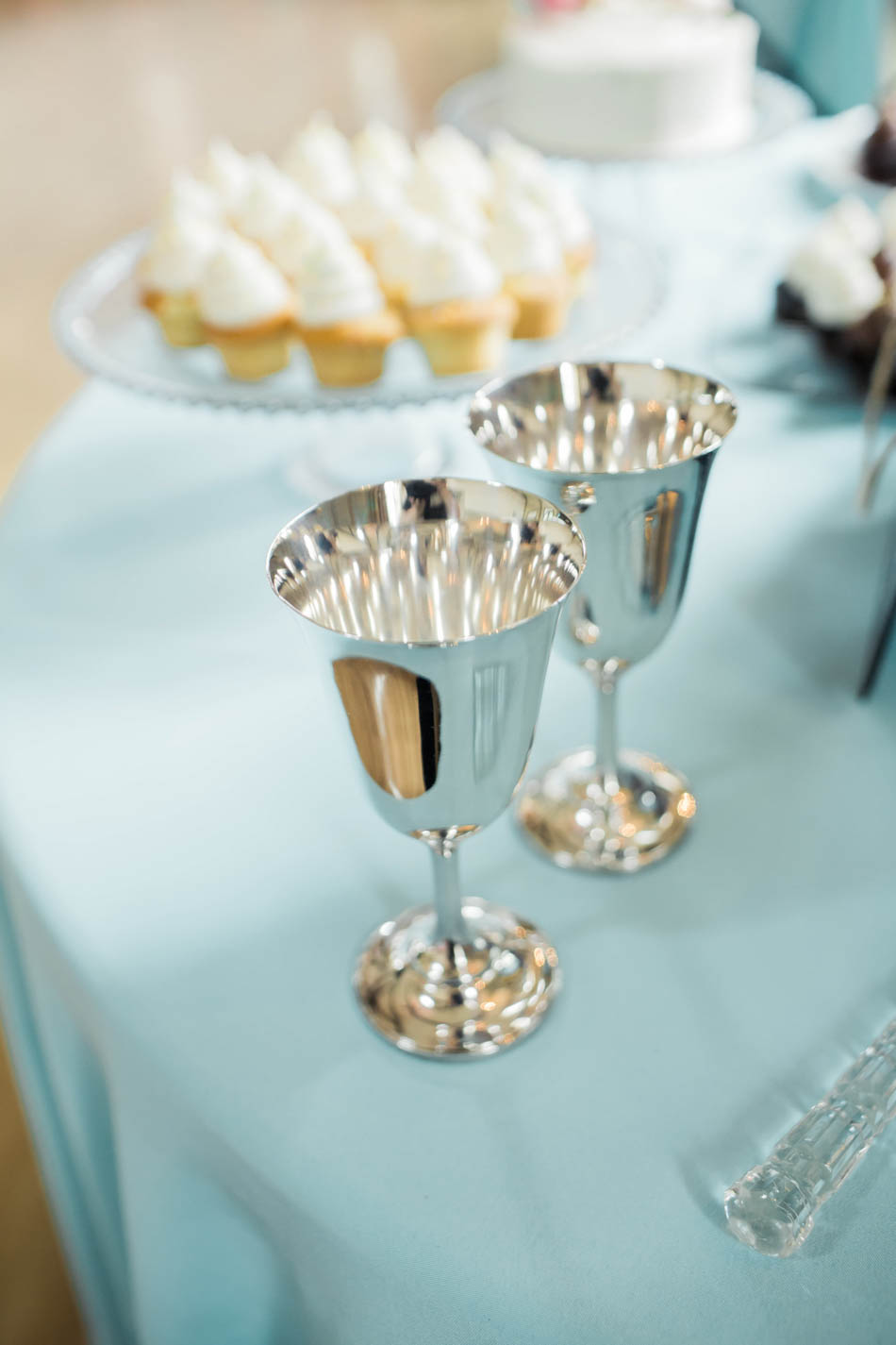 Silver flute glasses are set up with cupcakes and a petit cake with large floral accents, I'on Creek Club, Mt Pleasant, South Carolina. Kate Timbers Photography. http://katetimbers.com