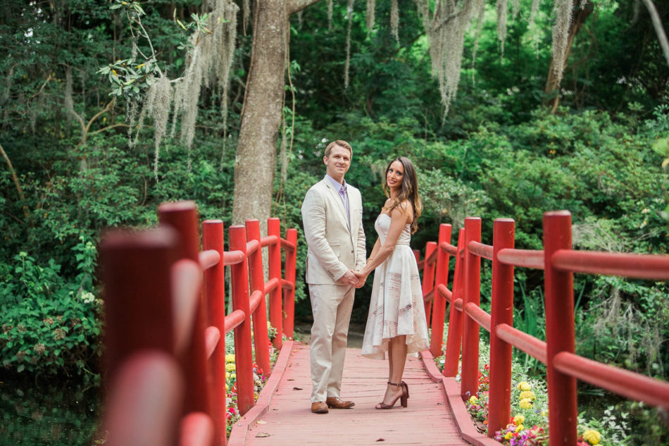 Engaged couple stand on a red bridge, Magnolia Plantation, Charleston, South Carolina. Kate Timbers Photography. http://katetimbers.com