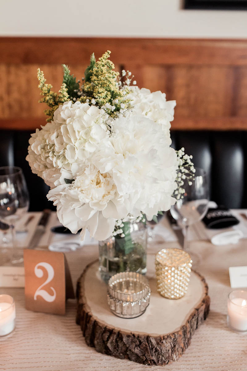 Flower centerpieces are accented with rustic wood details, Stars Rooftop & Grill Room, Charleston, South Carolina. Kate Timbers Photography. http://katetimbers.com