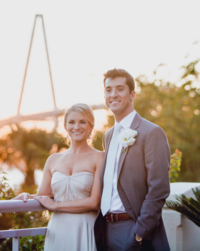 Bride and groom pose at sunset with Ravenel Bridge in background, Harborside East, Mt Pleasant, South Carolina. Kate Timbers Photography. http://katetimbers.com