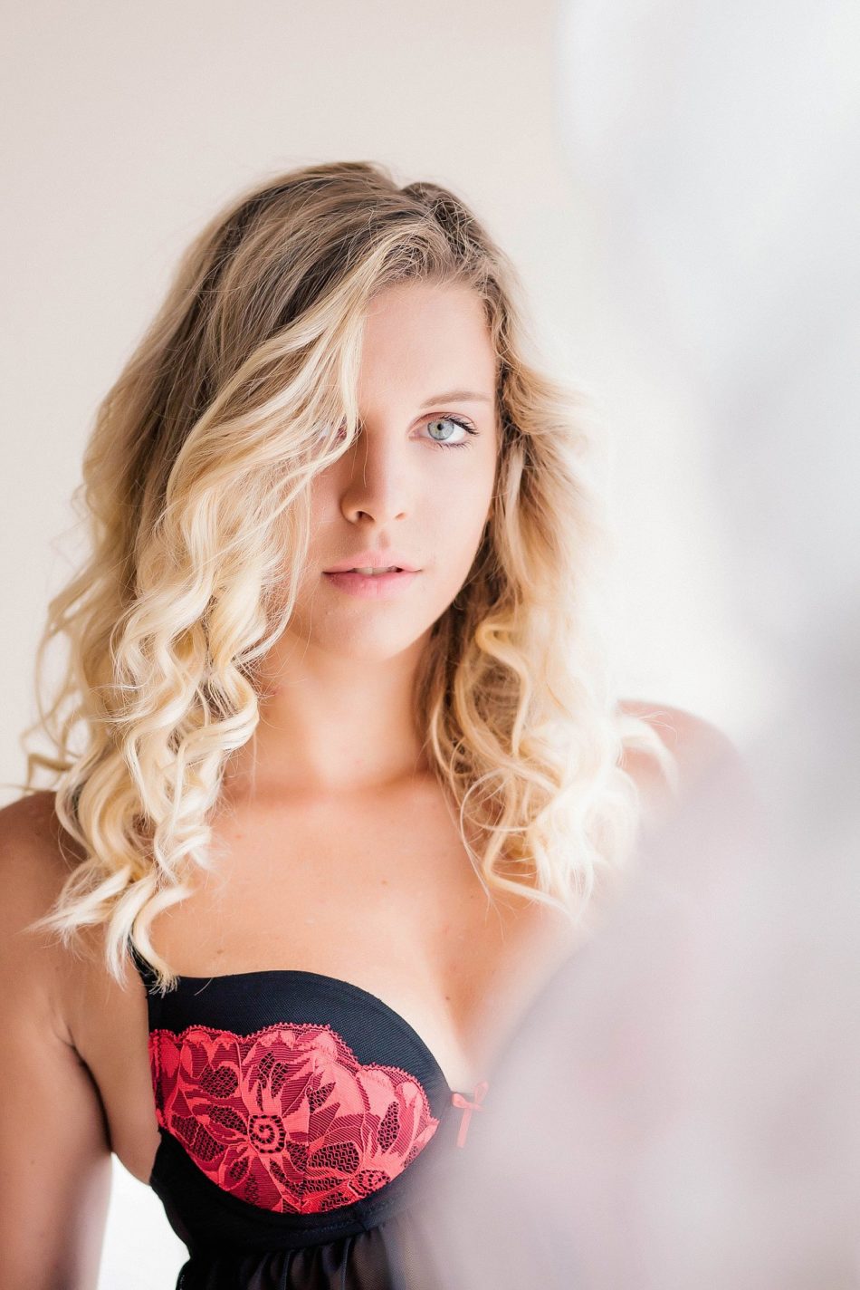 Audrey wears a red and black lingerie by window. Photography by Charleston Boudoir Photographer, Kate Timbers. Kate Timbers Photography. http://katetimbers.com #katetimbersphotography // Charleston Photography // Inspiration