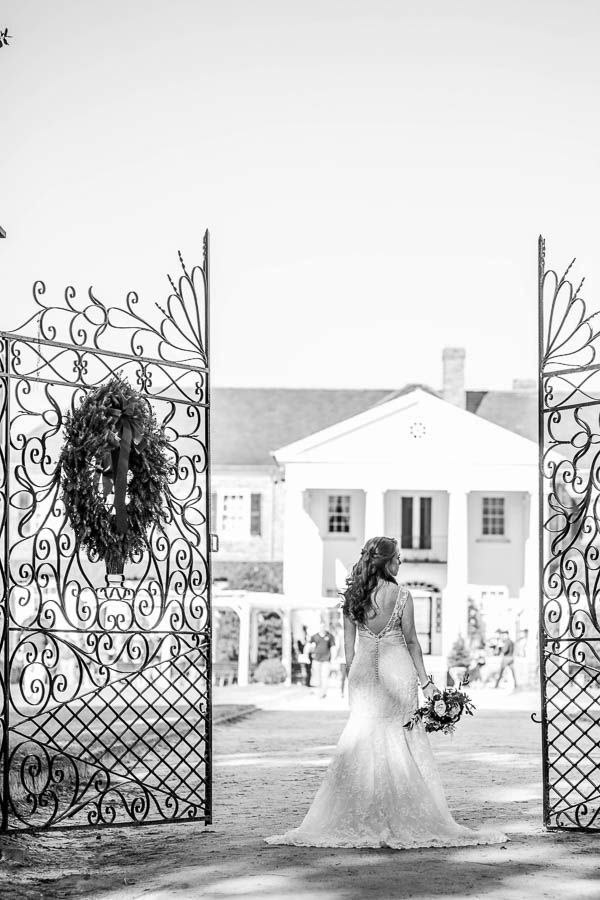 Bride stands by gate of estate, Boone Hall Plantation, Charleston, South Carolina. Kate Timbers Photography. http://katetimbers.com #katetimbersphotography // Charleston Photography // Inspiration